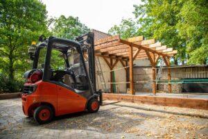 Mit Gabelstapler Holzbalken auf ein Carport heben