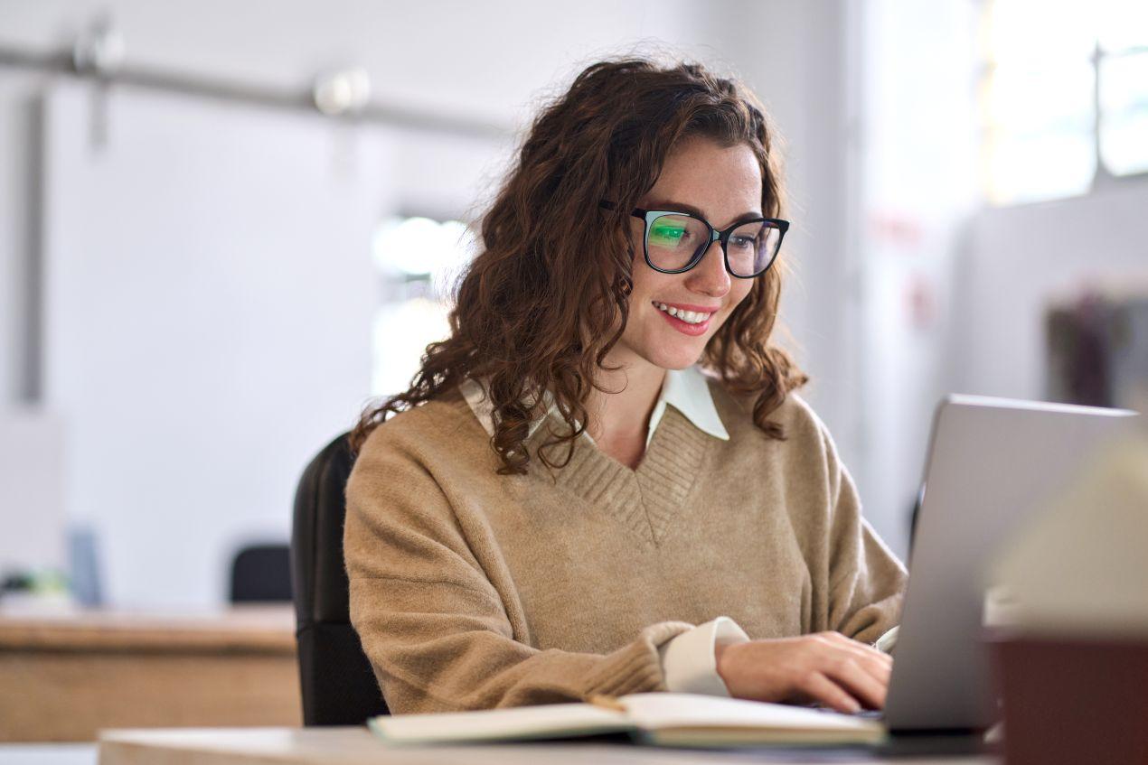 E-Learning Hygiene: Frau lernt am Laptop im Buero als Teil einer digitalen Mitarbeiterschulung