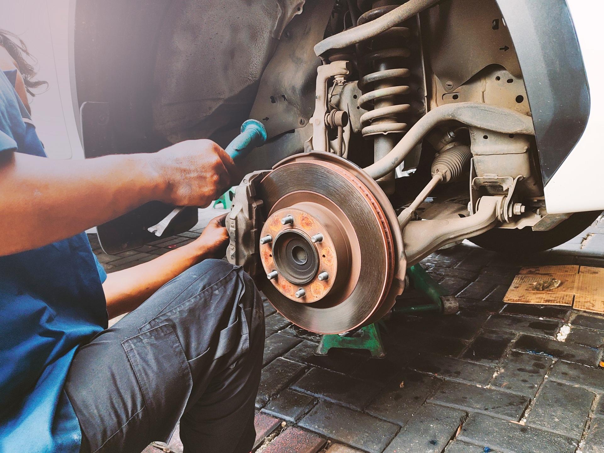 Mechaniker repariert Bremsanlage | Auto abmelden Hamburg
