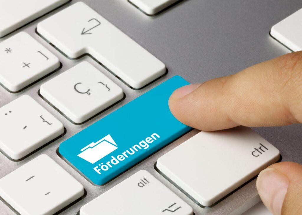 Finger tippt auf Tastatur mit Foerderungstaste – Symbolbild fuer staatliche Unterstuetzung bei Regenwasseranlage