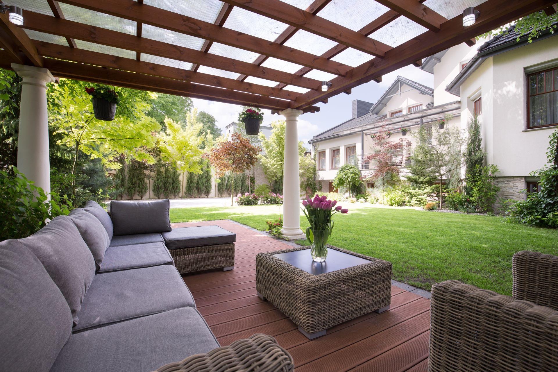 Terrasse mit überdachter Pergola und gemütlicher Sitzgruppe im Garten